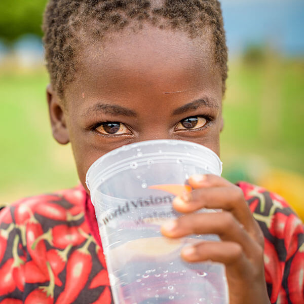 受助兒童用世界宣明會的杯子喝水。
