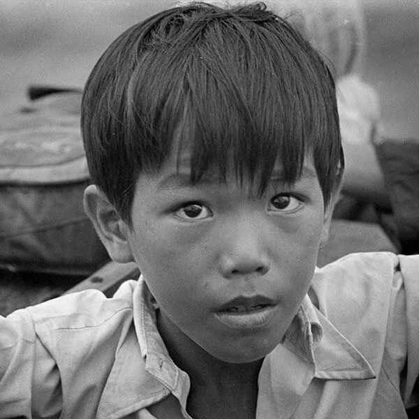 A Vietnamese refugee boy looks at the camera.